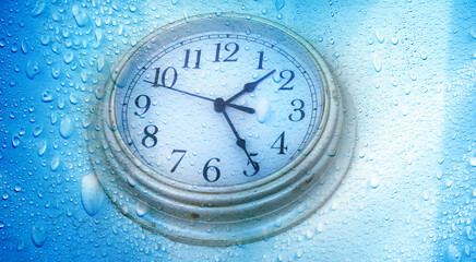 Wall Mural - close up abstract raindrops and clock face over blue background