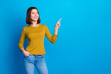 Wall Mural - Photo of dreamy cute woman wear shirt looking showing finger empty space isolated blue color background