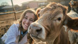 A young woman takes a close-up selfie with a cow in a sunny rural setting.