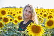 Happy woman in Ukrainian clothes - embroiderers in a field of sunflowers.