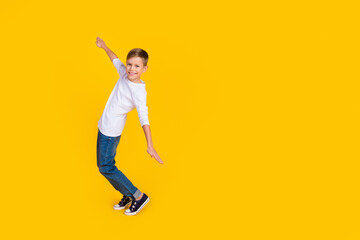 Wall Mural - Full length photo of good mood funky boy wear white shirt arms sides dancing empty space isolated yellow color background