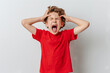 © Fabio - Angry boy in red tee holding his head shouting angrily