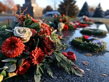 A Table With A Wreath And Flowers On It. The Flowers Are Red And White