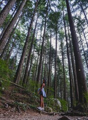 Beautiful closeup of a woman against a long trees in the forest