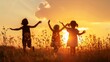 A silhouette of three happy children playing on the field as the sun sets. They are having fun in nature and getting ready to go to school.