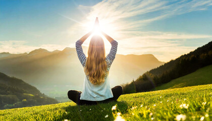 Wall Mural - A young woman with long blond hair is meditating with her legs crossed and hands clasped above the head, sitting on a green meadow on a hill. Generative Ai.