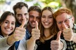 Friends smiling and giving thumbs up in a close-up shot, symbolizing approval and happy camaraderie