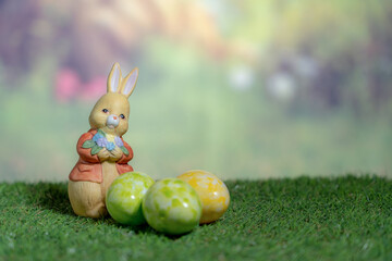 A statue of a rabbit holding colored Easter eggs. Easter, Pascha or Resurrection Sunday concept