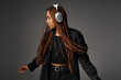 © LIGHTFIELD STUDIOS - relaxed and young African American woman in 20s with headphones dancing to music on grey backdrop