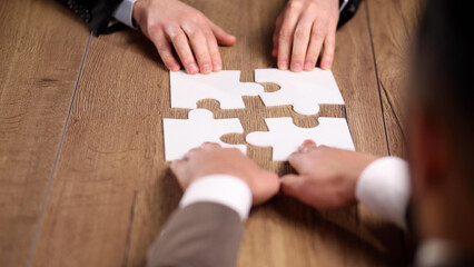 Wall Mural - close up.business partners putting together a puzzle ,sitting at office Desk