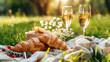 A picnic on the grass with wine and croissants.breakfast with a croissant.French breakfast. Food on the street.Croissants in nature. Romantic breakfast.Dinner party with champagne.Dinner.Summer