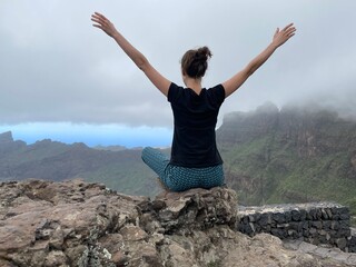 Poster - woman meditates on top of large rock overlooking scenic area