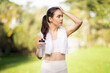© Prostock-studio - An attentive young woman wipes sweat from her forehead while holding a water bottle