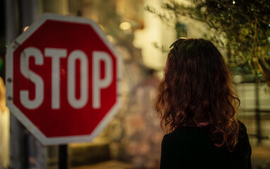 The girl stopped at a stop sign.