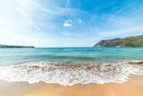 Fototapeta Londyn - Blue sky over a beach with golden shore and turquoise water