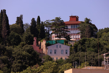 Wall Mural - Beautiful houses and city streets of the southern city with green plants, public place in Turkey, on a summer sunny day