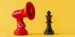 Megaphone and chess king on yellow background, marketing strategy concept