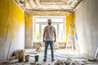 Rear View of a Worker Observing a Room with Fresh Yellow Paint and Renovation Mess