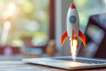 Wall Mural - Rocket coming out of laptop on office table, startup concept