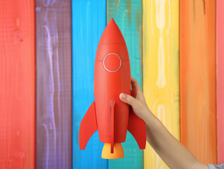 Wall Mural - Launch of a red rocket on colorful wooden background, 