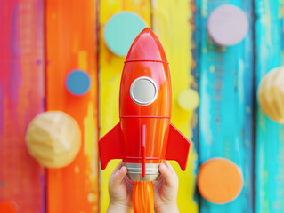Wall Mural - Launch of a red rocket on colorful wooden background, 