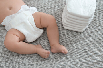 Sticker - Cute little baby in diaper on grey blanket, above view