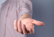 © New Africa - Man holding something in his hand on grey background, closeup