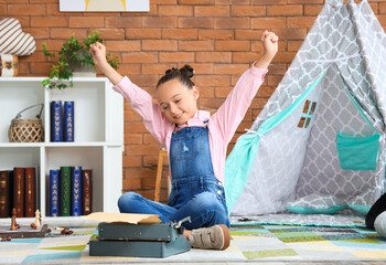 Wall Mural - Cute little girl with typewriter at home