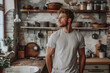 © barmaleeva - Cheerful young man in t shirt standing on the rustic kitchen. Generative AI