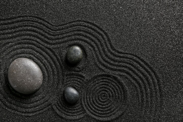 Spa stones on black sand with lines. Zen concept