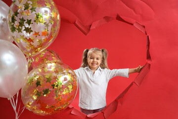 Canvas Print - Happy smiling little girl with torn paper heart and balloons on red background