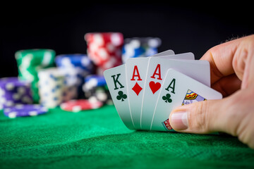 A hand holding four cards, one of them is a Ace and the other three are King on a green poker table with casino chips in the background. The style is similar to by black background, --ar 3:2