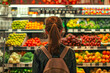 Rear view of a woman shopping for groceries, fruits and vegetables, struggling with inflated prices, recession, reflecting the impact of the economic downturn