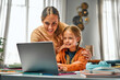 Online training for children. Parent looking at child setting application for connecting to distant lesson