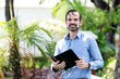 © caav - Retrato de hombre de negocios adulto latino contento por cerrar contrato de negocio en un día soleado