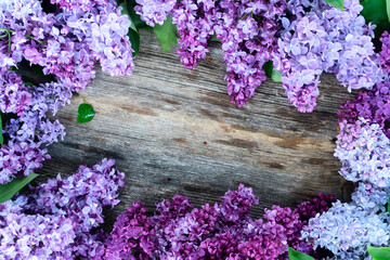 Poster - Fresh lilac flowers frame over wooden background with copy space, flat lay floral composition