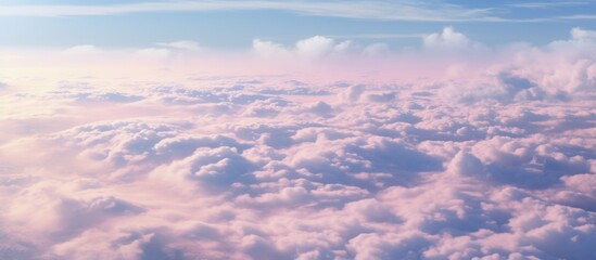  Fluffy white clouds floating in a clear blue sky above a vibrant pink and blue horizon
