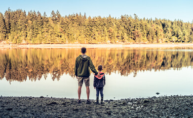 Wall Mural - Adventurous family father son exploring a scenic lake forest setting and enjoying the breathtaking views on their vacation, family vacation, summer travel