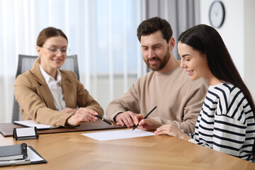 Poster - Couple signing document while having meeting with lawyer in office, selective focus