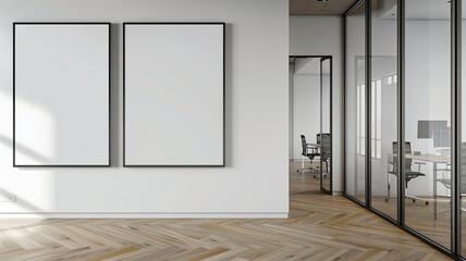 mockup of two blank posters on a wall in an office with glass doors, wooden floors, white walls, and ceiling lights.