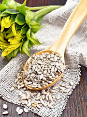 Wall Mural - Seeds sunflower peeled in spoon on dark board