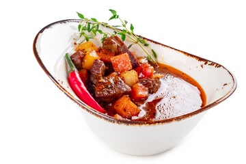 Wall Mural - Stew beef and vegetables in a bowl on a white background. The dish is stewed over low heat with spices and gravy