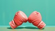 Intersecting pink boxing gloves against turquoise backdrop in a pastel composition for combat sports training