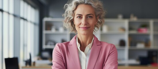 Poster - Cheerful female wearing a pink jacket standing in front of a laptop computer