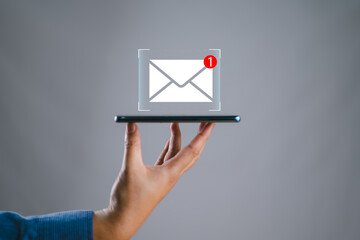 Fototapete - hand holding the smartphone shows the icon for new email, send an information message email. smart SMS mail on digital. business communication contact newsletter concept. marketing social media.