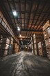 A vast warehouse space filled with stacked crates, pallets, and boxes, stretching into the distance under dim industrial lighting, Generative AI