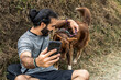 adult male mestizo settling in with his border collie dog for a selfie photo