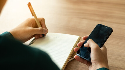 Wall Mural - businessman working at work table,home office desk background, checklist writing planning investigate enthusiastic concept. Male hand taking notes on the notepad.	
