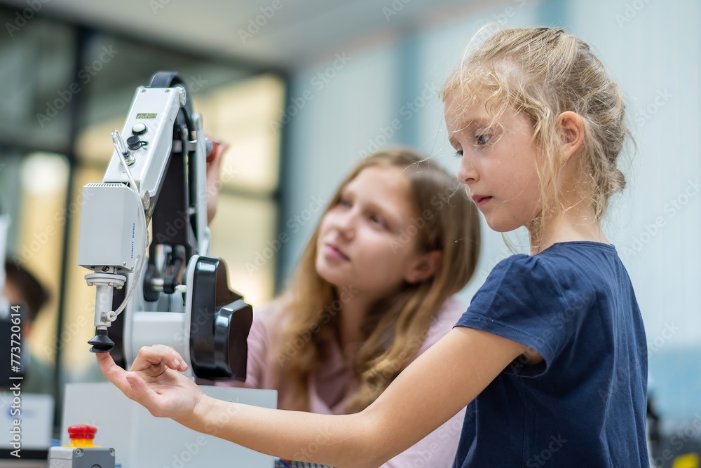 Kid female teen child enjoy Machine Learning Robot arm is Moving Under ...