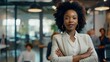 © Koko Art Studio - Attractive young african american business woman working at modern creative office, happy confident female leader manager wearing a suit standing outside conference room.
